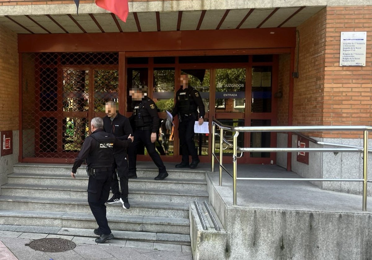 Agentes de la Policía Nacional custodian al sospechoso de tirar a un hombre por la ventana, a su salida del juzgado de Mieres.