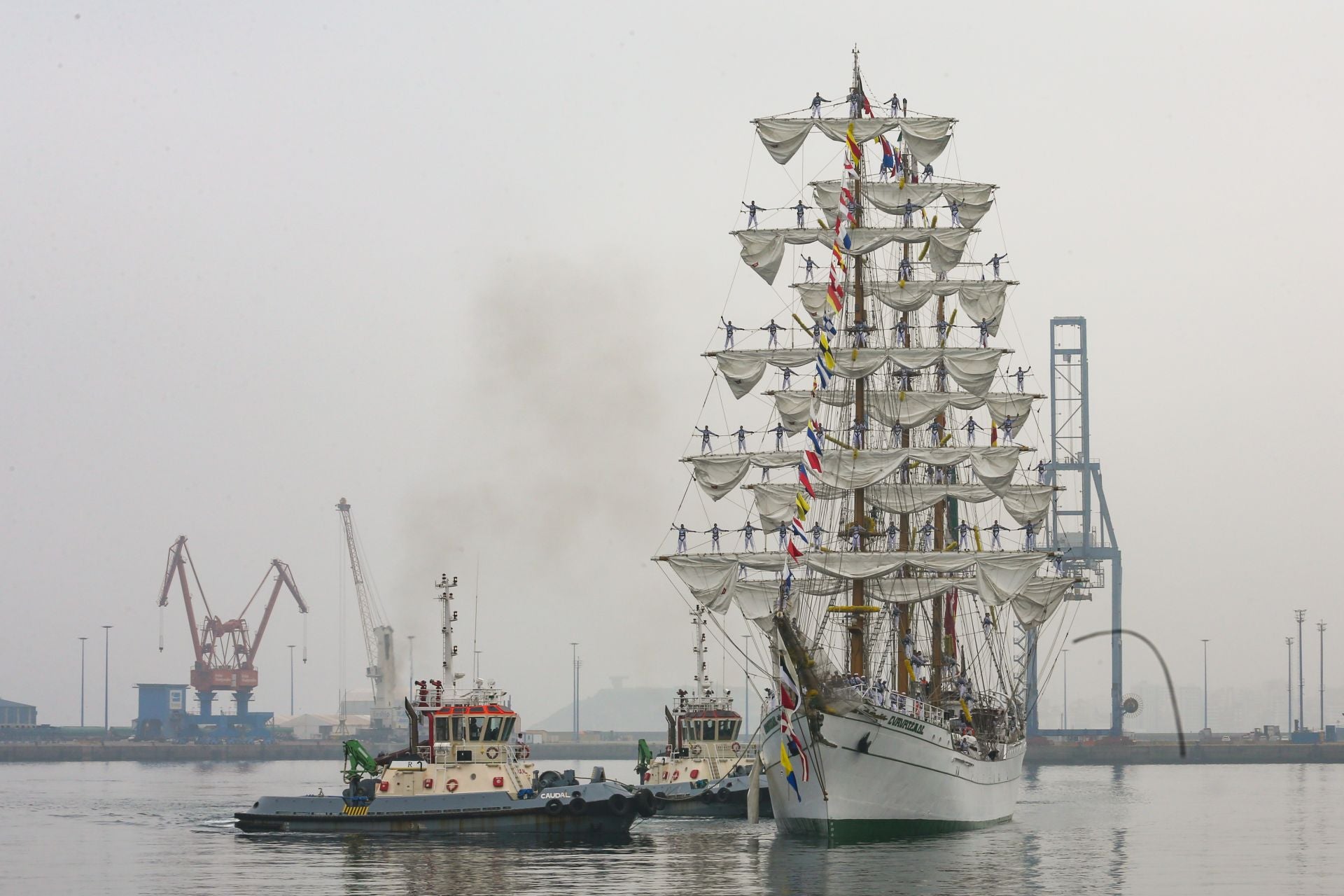 El buque escuela de la Marina de México, 'Cuauhtémoc', durante la maniobra de atraque en El Musel, con los cadetes en las vergas y aparejos de la nave.