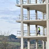 Dos operarios trabajan en la construcción de un edificio de viviendas.
