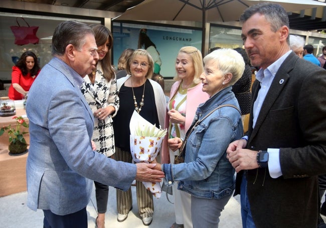 El alcalde saluda a una mujer en la feria.