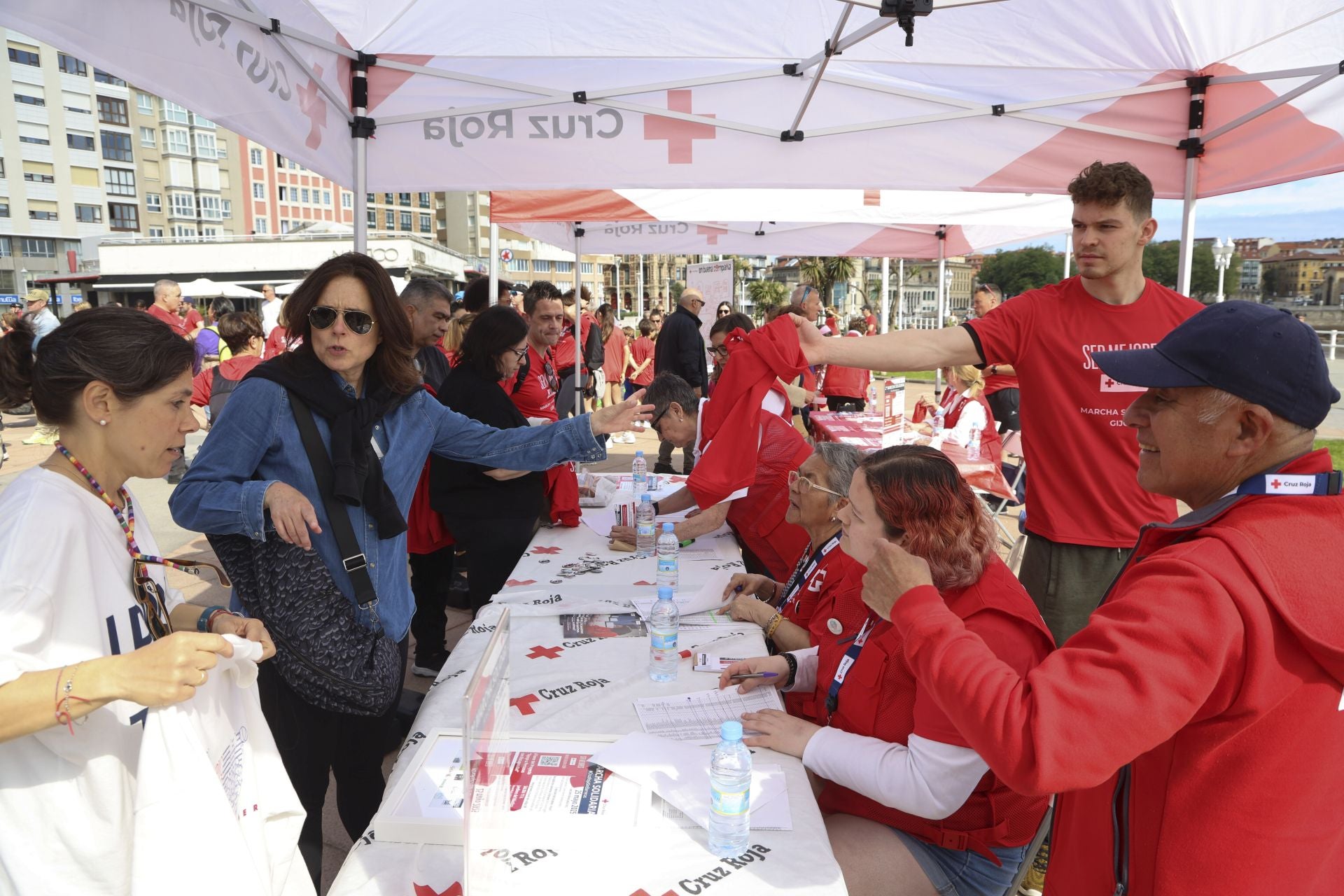 Marea de mil camisetas rojas en la marcha de Cruz Roja en Gijón