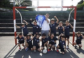 Pereira, ayer con una camiseta del Real Avilés de su época de jugador blanquiazul junto a los jugadores del equipo que entrena en el Colegio San Fernando.