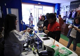 Aficionados del Real Avilés retirando entradas para el partido en la tienda.