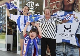 Mara Clemente, María Dolores Valdés y la pequeña Deva Berciano lucen los colores del Real Avilés Industrial a la puerta de la tienda oficial del club.