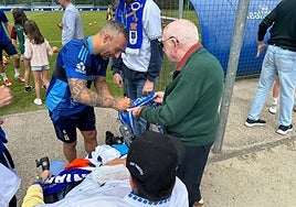 Santi Cazorla firma la bufanda de 'Lolo', un veterano aficionado del Real Oviedo.