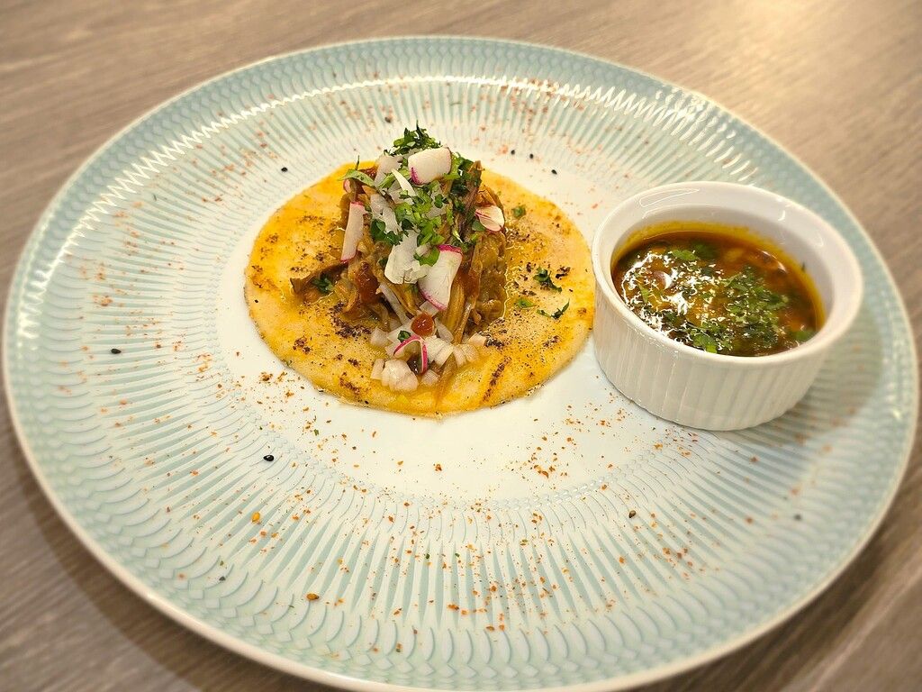 Tortilla de maíz, lechazo cocinado a baja temperatura, salsa casera de chiles ahumados, rabanito baby, cebolleta, cilantro, limón y birria