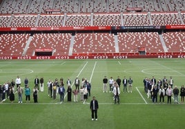 Amigos, familiares, compañeros y demás invitados al adiós del lateral posan sobre el césped de El Molinón dibujando el nombre de Cote con el jugador en primer plano .