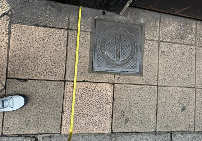 Un empresario de la calle Munuza coloca un metro en la acera.