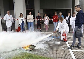 El personal del hospital practicó en el exterior cómo apagar un fuego real con un extintor.