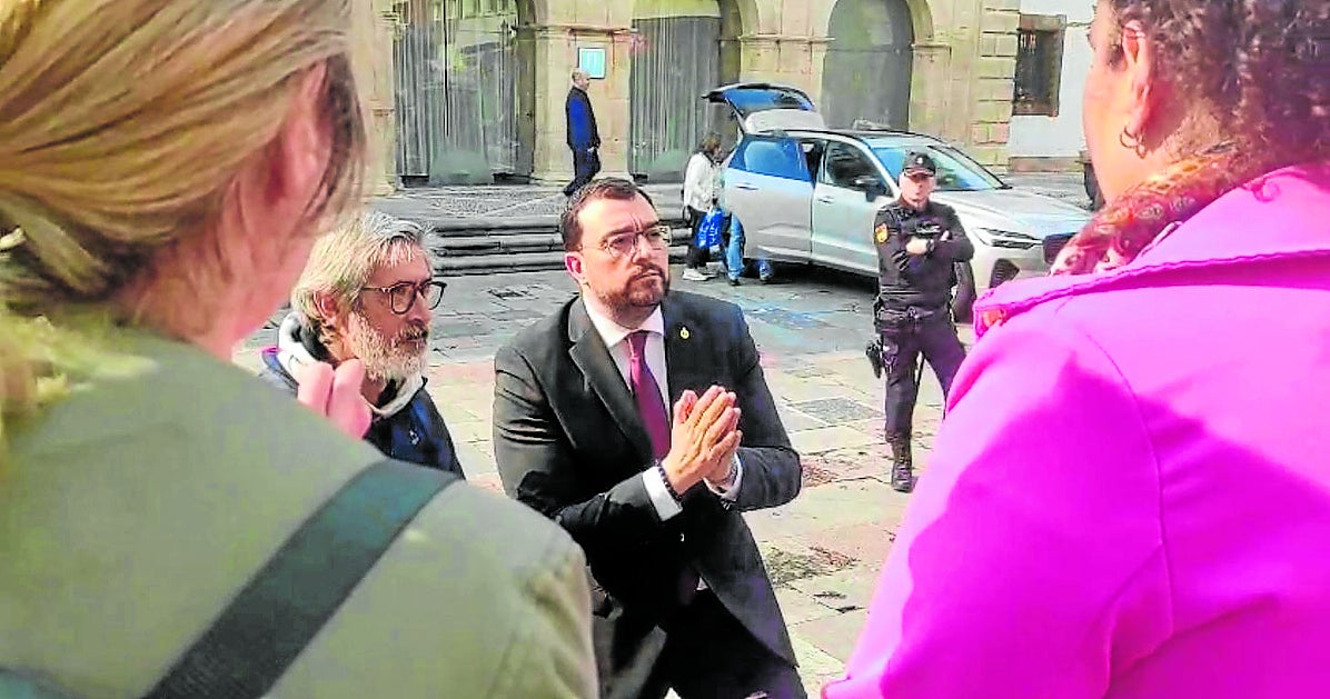 Adrián Barbón habla con varios docentes, a la salida del Hotel de la Reconquista, en la tarde de ayer.