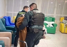 Dos agentes de la Guardia Civil asisten a un usuario de la residencia geriátrica de Siero donde se produjo el incendio.