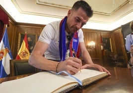 Natalio firma en el libro de honor del Ayuntamiento de Avilés.