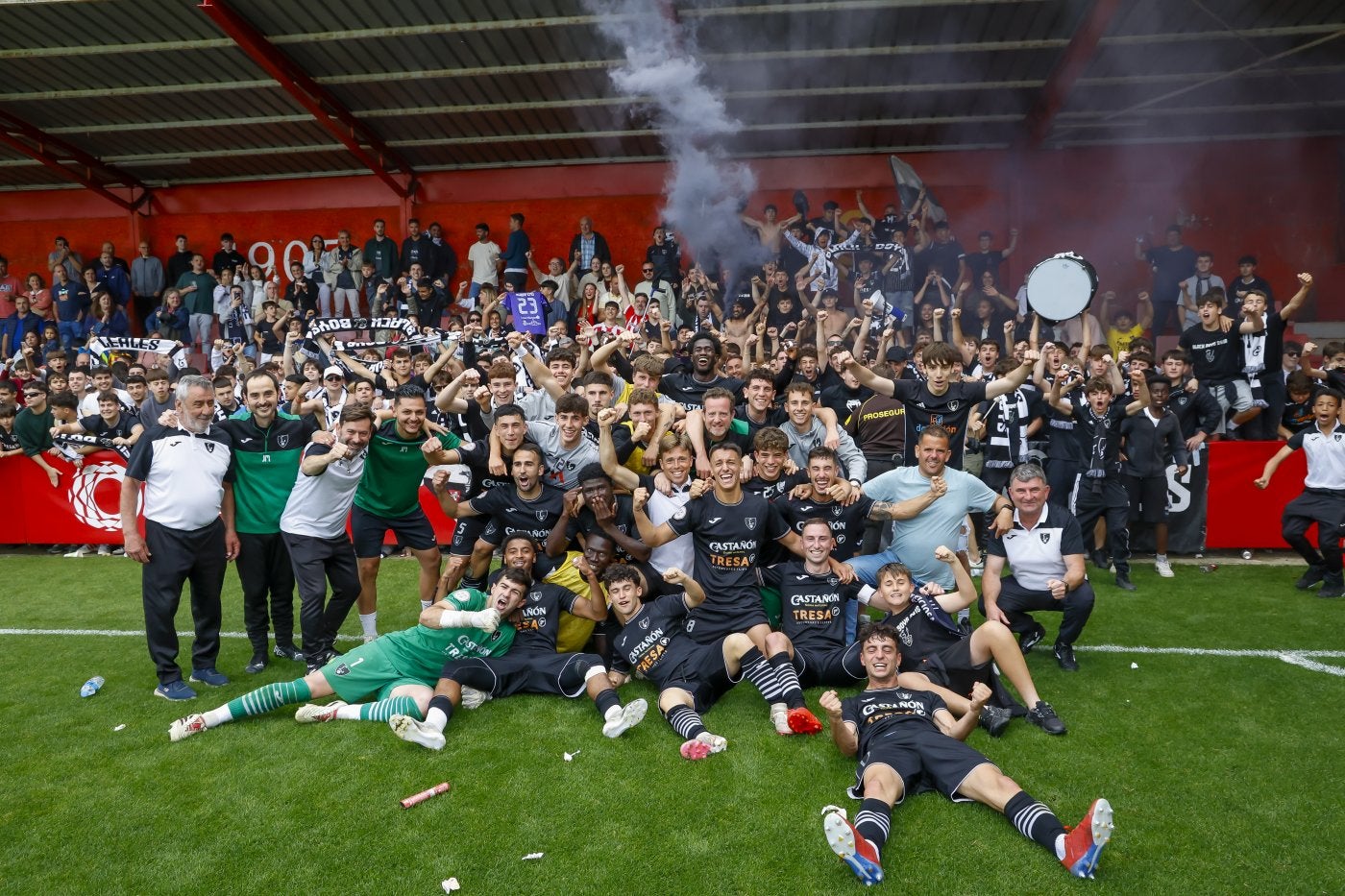 La plantilla y cuerpo técnico del Lealtad festejan la clasificación sobre el terreno de juego del campo de Mareo.