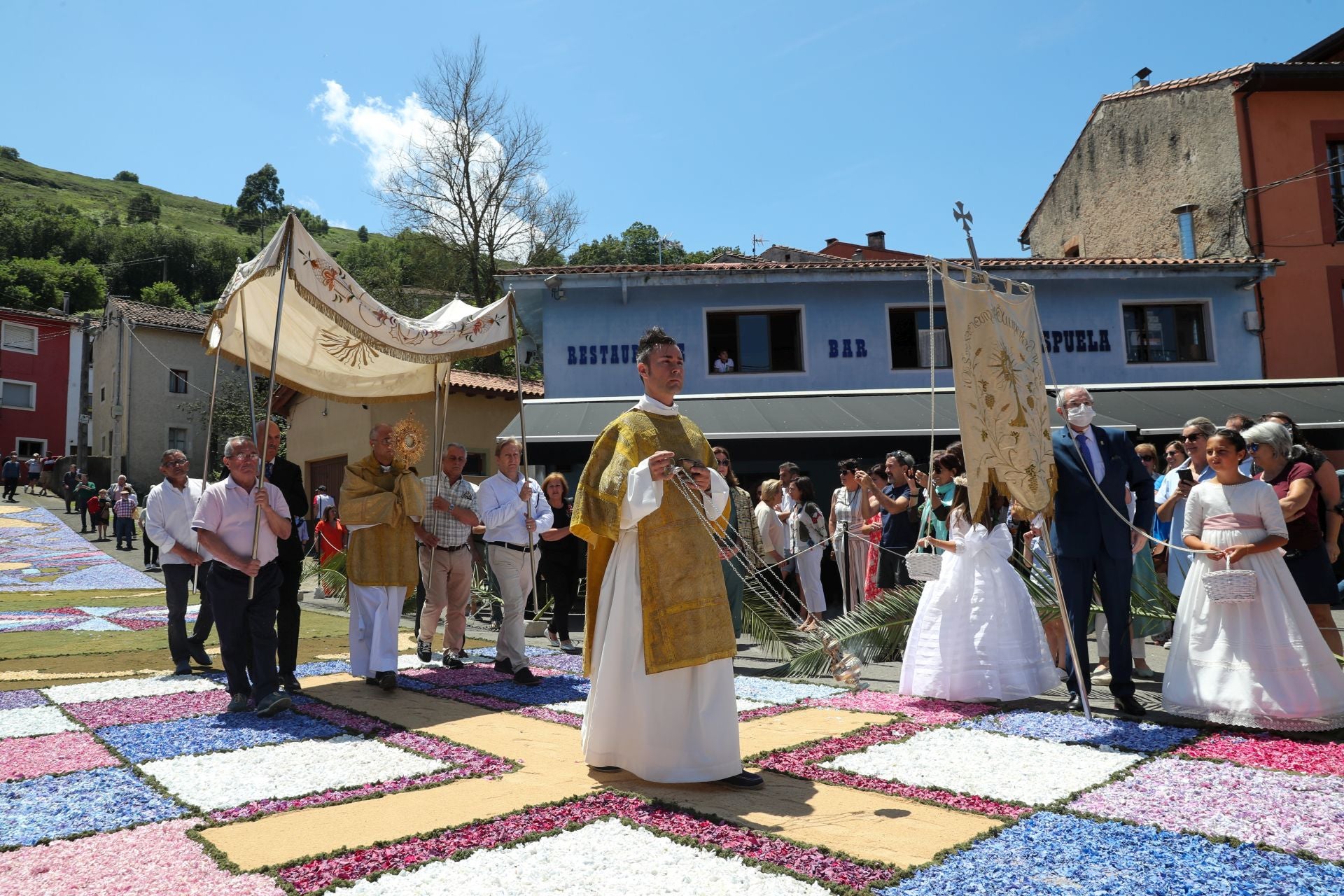 Procesión de La Sacramental en Cué, con niños vestidos de Primera Comunición.