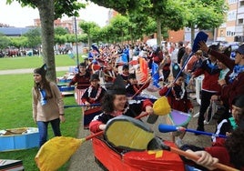 Los alumnos, con las piraguas de cartón y los remos, durante el recorrido por el parque