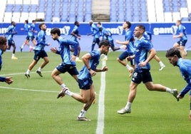 Los jugadores del Real Oviedo realizan un ejercicio de calentamiento durante el entrenamiento de ayer en El Requexón.