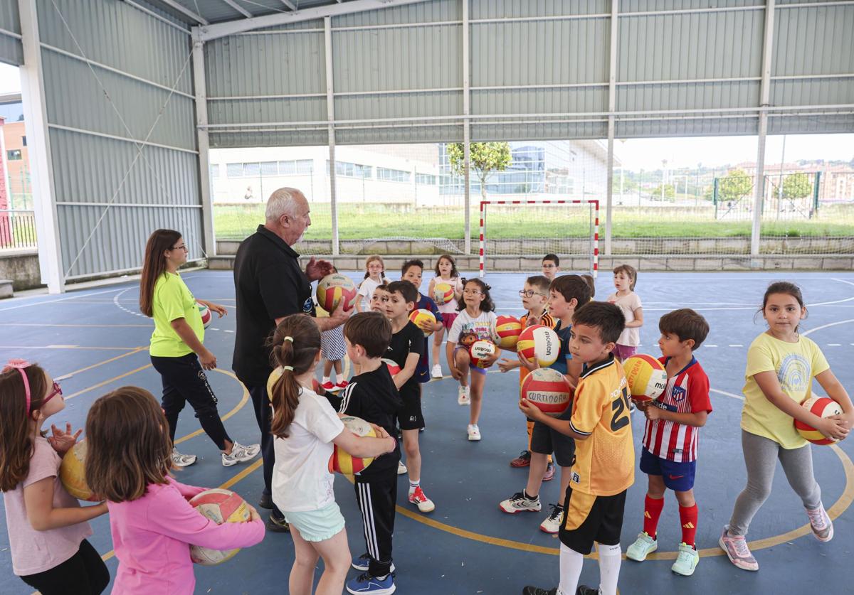 Rufo Álvarez reparte balones entre los alumnos antes del inicio de la actividad en el Colegio Público Quirinal.