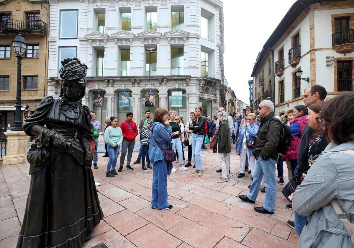 Un grupo de turistas junto a la estatua de La Regenta, en Oviedo.