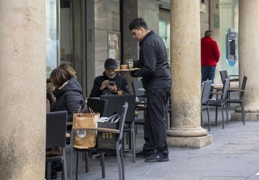 Un camarero atiende una terraza.