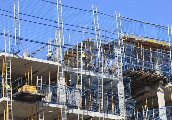 Trabajadores en la construcción de un edificio de viviendas en Gijón.