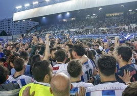 Jugadores y aficionados del Real Avilés celebran el ascenso sobre el césped del Suárez Puerta.