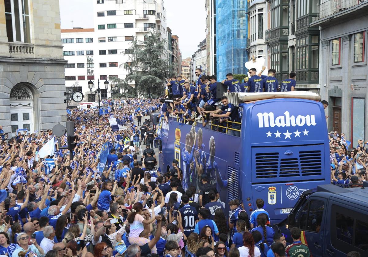 Una multitud enfervorecida escolta al vehículo descapotable de los jugadores a su paso por las calles del centro de la ciudad.