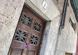 Crespón morado con la frase 'Ni una más' colocado en el portal donde mataron a Susana Sierra.