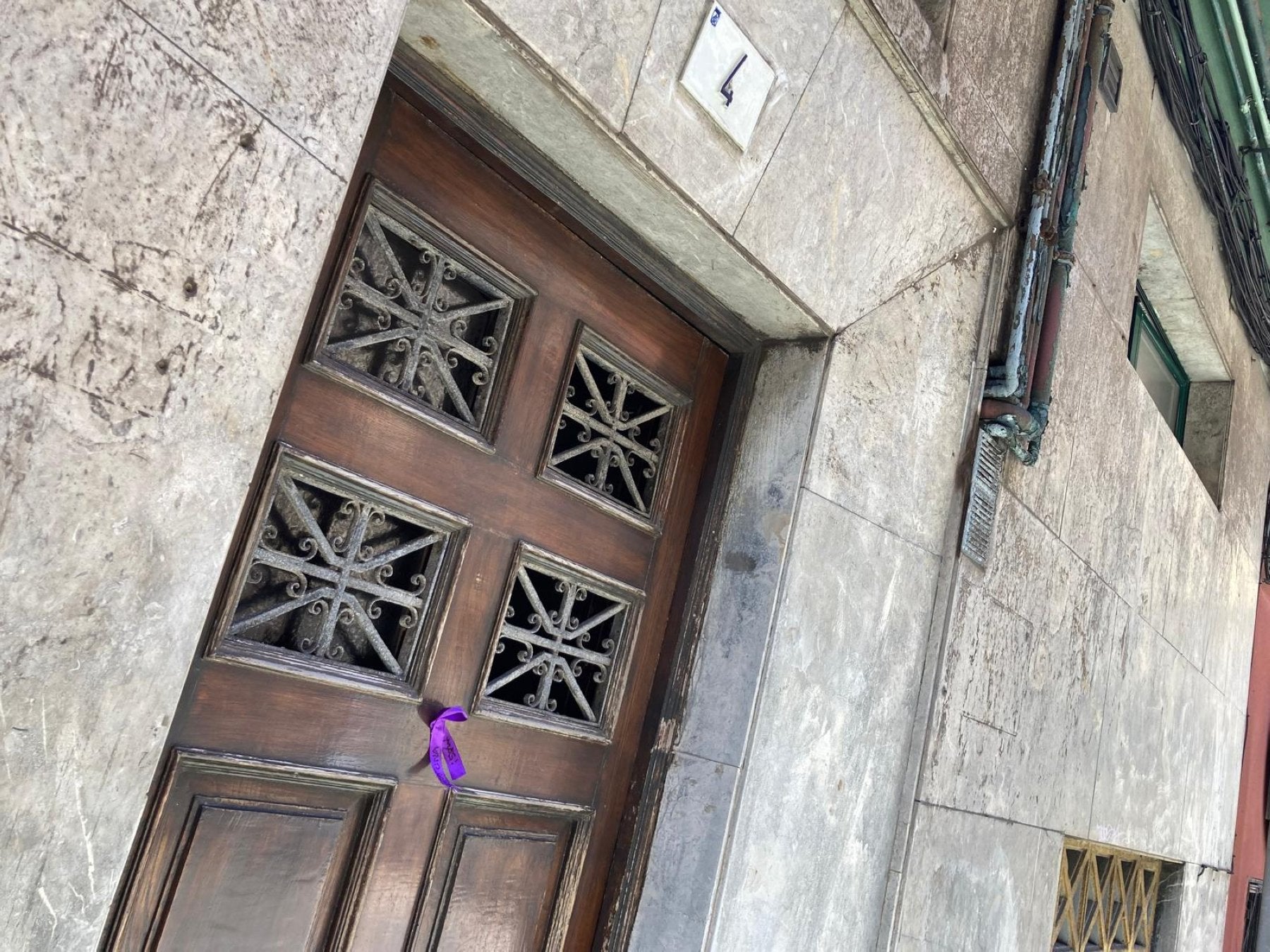Crespón morado con la frase 'Ni una más' colocado en el portal donde mataron a Susana Sierra.