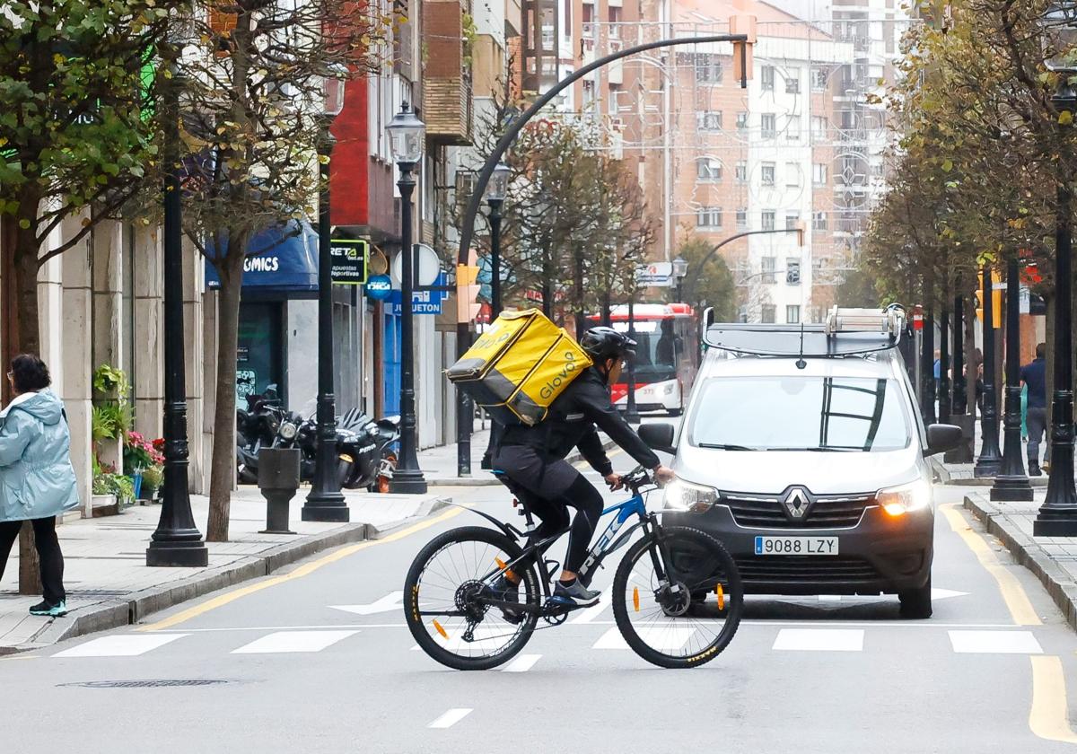 Un repartidor de Glovo circula por una calle de Gijón.