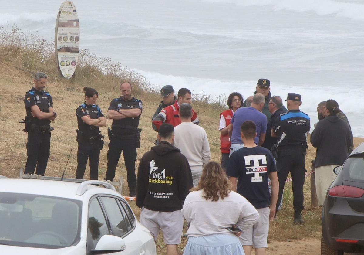 Policía, Guardia Civil y miembros de Cruz Roja, en la playa de Verdicio, atienden a los familiares del pescador fallecido.