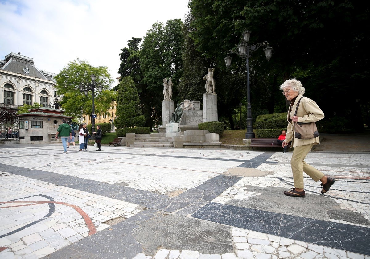 Una señora pisa uno de los parches de cemento del mosaico.