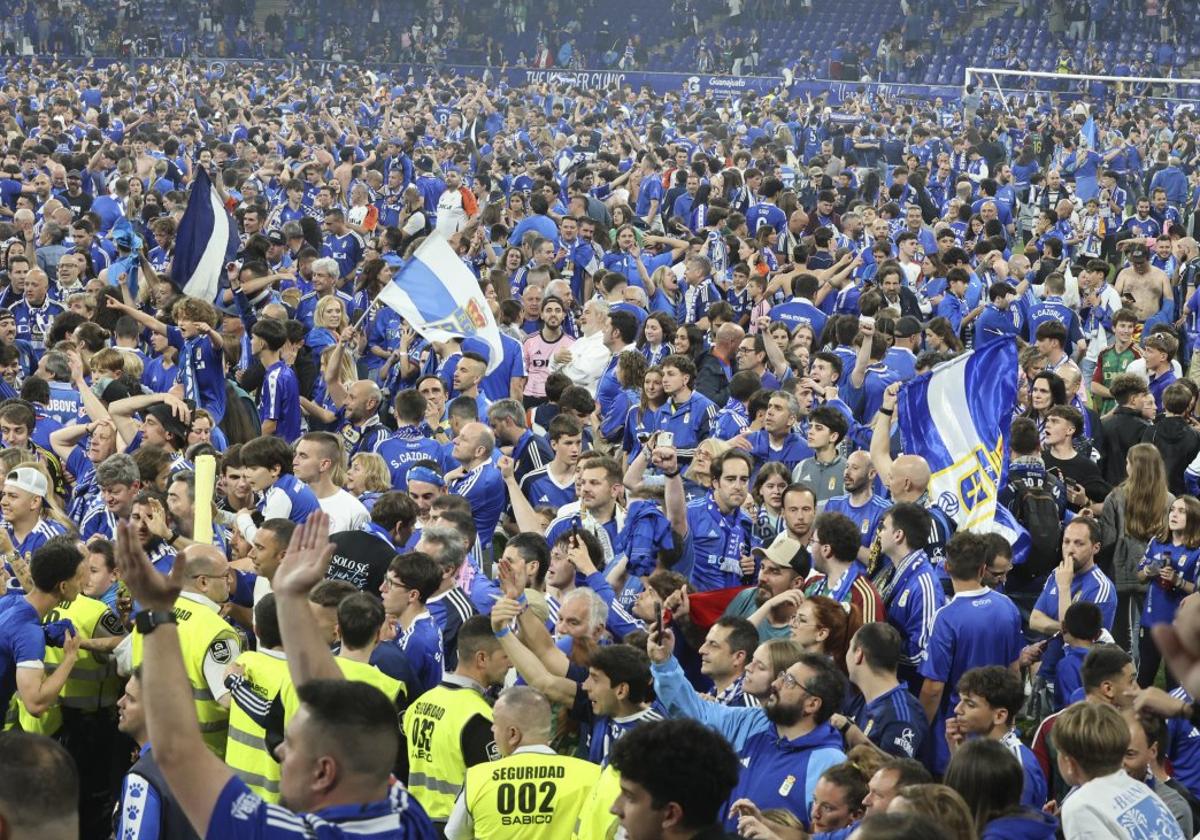 Los aficionados azules celebran el ascenso de su equipo sobre el césped del Carlos Tartiere.