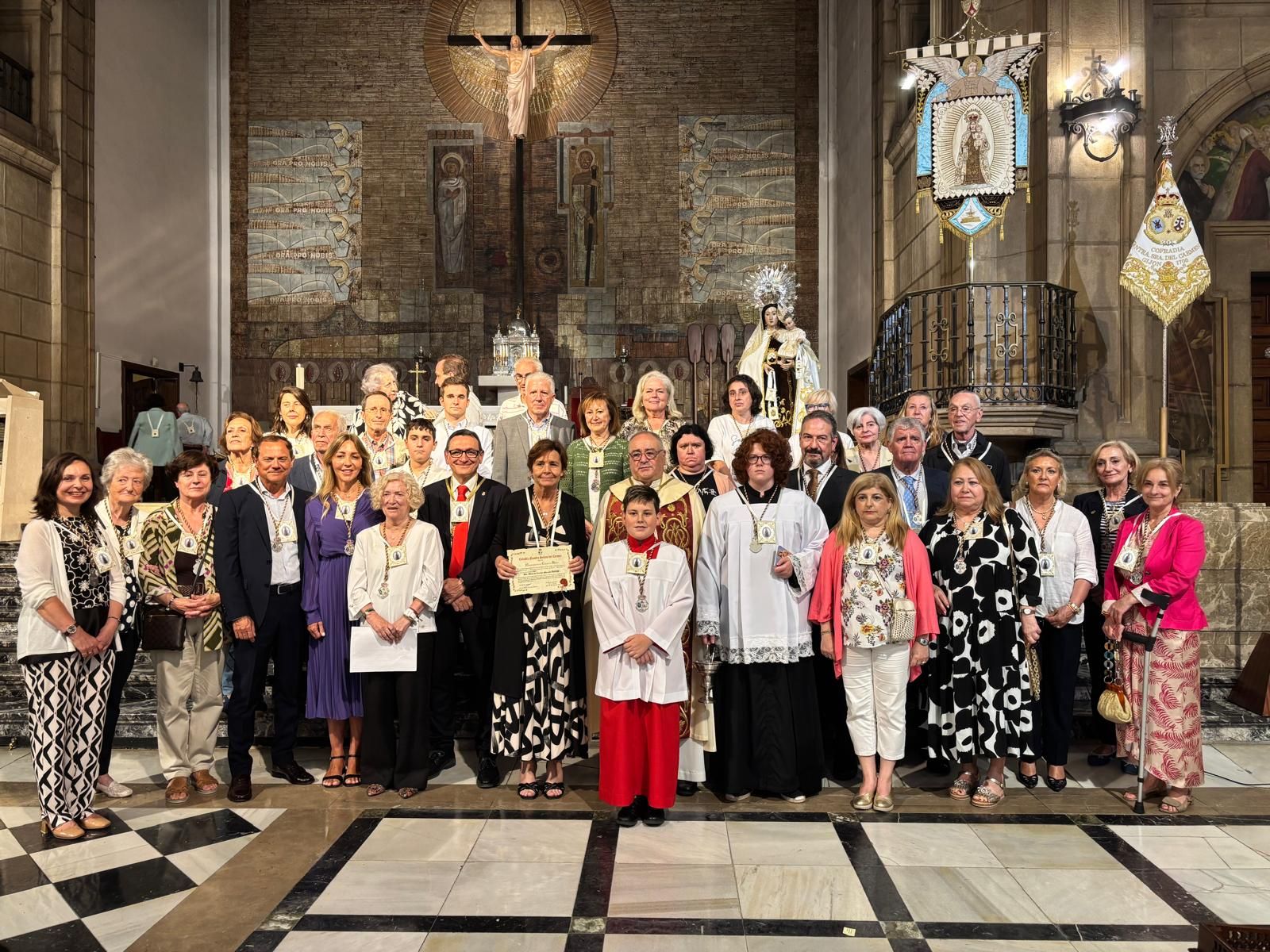 Carmen Moriyón posa junto a los nuevos cofrades que recibieron los escapularios y la medalla de la Cofradía de Nuestra Señora del Carmen.