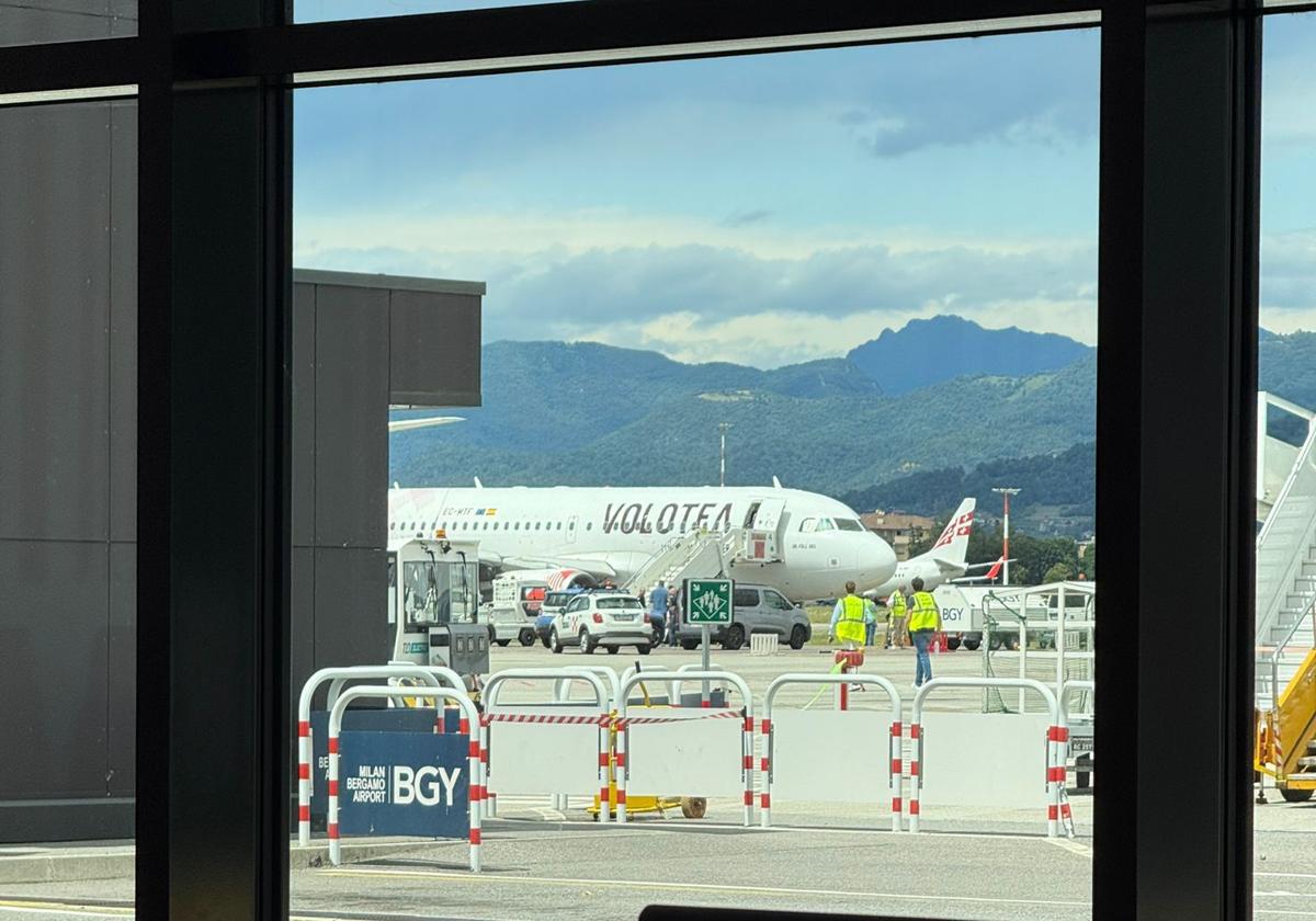 El avión de Volotea, con una carpa bajo el motor que absorbió a una persona, es examinado por miembros de la Policía y de Bomberos.