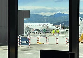 El avión de Volotea, con una carpa bajo el motor que absorbió a una persona, es examinado por miembros de la Policía y de Bomberos.