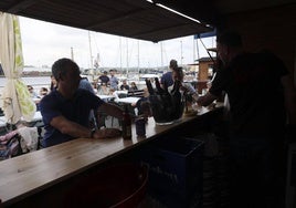 Uno de los puestos gastronómicos con gente sentada en las mesas detrás.