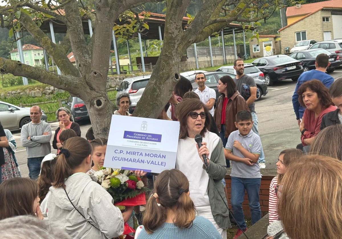 La profesora Mirta Morán, con el nuevo cartel del colegio durante el homenaje, en Guimarán