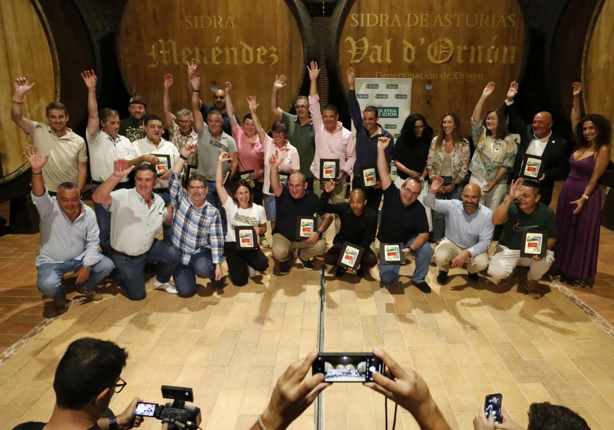 Ganadores históricos del Campeonato regional de Escanciadores y autoridades simulan echar un culín en Sidra Menéndez, en Gijón.