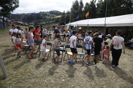 Los más pequeños juegan al juego de la silla en el prao de la fiesta.