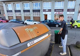 Trabajador de un restaurante de Gijón usando el contenedor marrón