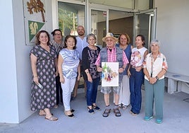 El artista Valentín del Fresno, en el centro, muestra con mucho orgullo el cartel que ha diseñado para las fiestas de la parroquia de Somió, en el centro social de los vecinos, junto a la presidenta de la asociación de vecinos San Julián, Soledad Lafuente, y el resto de la junta directiva.