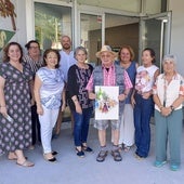 El artista Valentín del Fresno, en el centro, muestra con mucho orgullo el cartel que ha diseñado para las fiestas de la parroquia de Somió, en el centro social de los vecinos, junto a la presidenta de la asociación de vecinos San Julián, Soledad Lafuente, y el resto de la junta directiva.