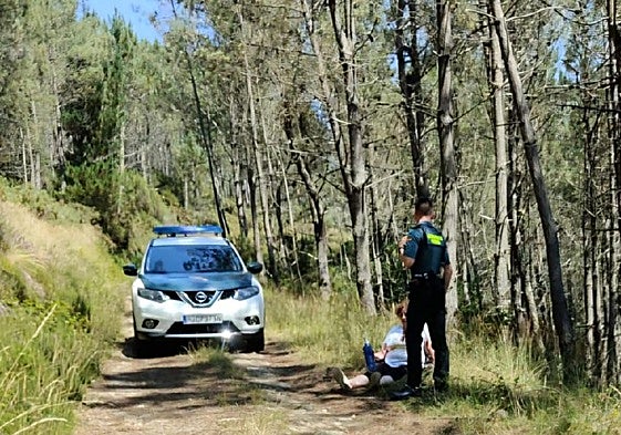 Un agente, con la mujer afectada.