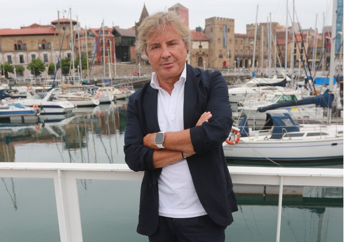 El mediático empresario, Ángel Lorenzo, posa en el espigón con el casco histórico de Gijón al fondo.