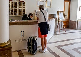 Un viajero, en recepción del oscarizado Hotel Asturias, de la plaza Mayor de Gijón.