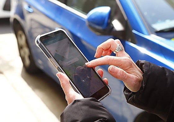 Una mujer realiza el pago de la zona azul.