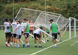 Los jugadores del Real Avilés transportan en el entrenamiento de este martes una portería portátil que tiene el club en La Toba.