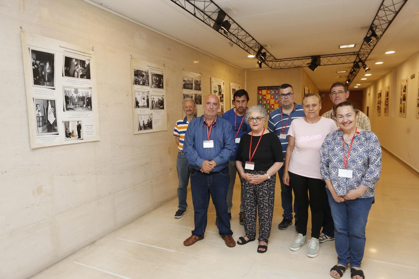 Algunos miembros de la Asociación de Sordos de Gijón posan junto a la exposición.
