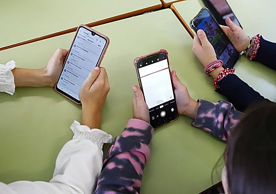 Estudiantes con móviles.