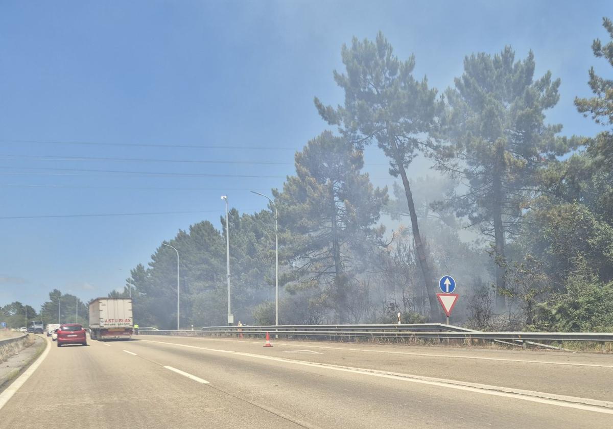 El humo provocado por el incendio dificulta llega a la carretera.